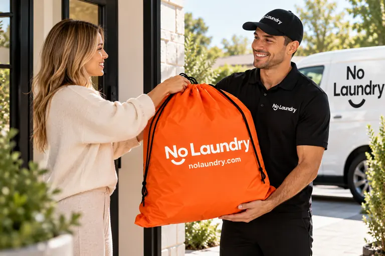 A NoLaundry pro hands an orange laundry bag to a customer at her door